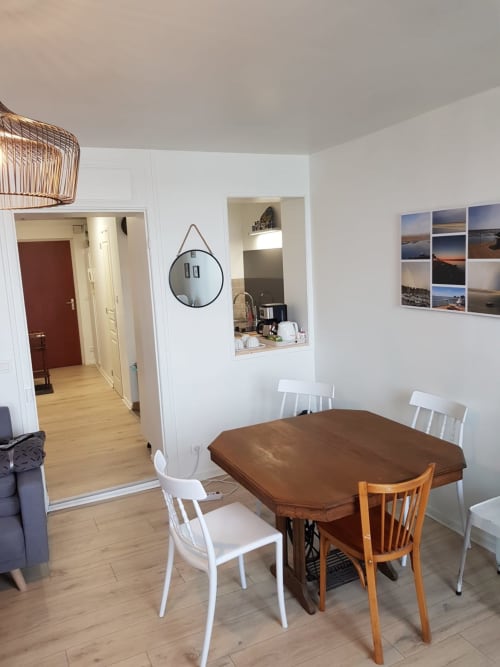 Salle à manger de la chambre d'hôtes Vue D'ici à Saint Valéry sur Somme avec table en bois, sièges variés et accès à la cuisine