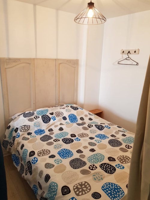 Chambre douillette du gîte Chez Anatole à Vue D'ici B&B, Saint Valery sur Somme, avec literie à motifs et luminaire suspendu