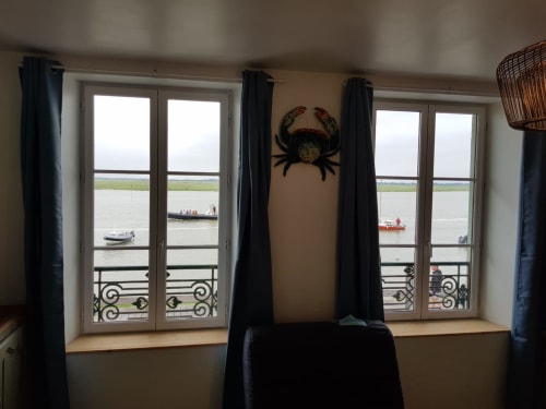 Chambre de cottage avec vue sur mer dominant le port de Saint-Valery-sur-Somme, décoration de crabe, rideaux noirs, portes-fenêtres