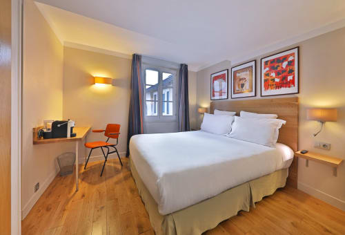 Chambre moderne de l'Hôtel Louvre Richelieu à Paris avec lit blanc, parquet et décoration contemporaine