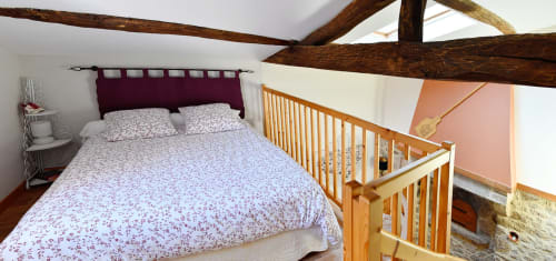 Cozy bedroom at Logis De La Bénétière with double bed, exposed beams, wooden crib, and garden views in Treize-Vents