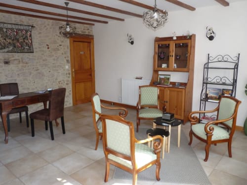 Elegant lounge area at Logis De La Bénétière in Treize-Vents with period furniture, exposed beams, and stone walls