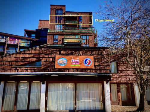 Exterior of the CosyArc Le Lauzières residence in Arc 1800 with colorful balconies and a nursery at the foot of the building