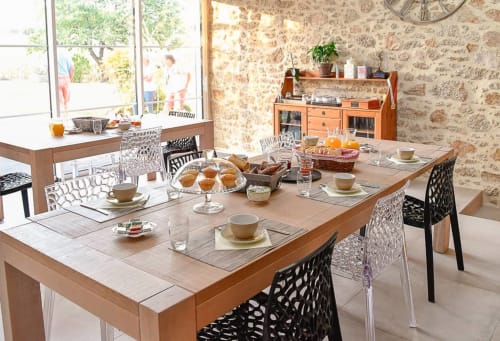 Salle à manger lumineuse du Logis De La Bénétière avec table dressée, chaises modernes et murs en pierre à Treize-Vents