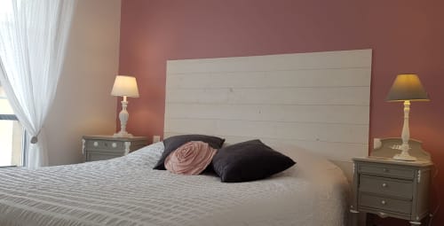 Chambre élégante à La Maison Virginie à Montargis avec tête de lit blanche, mur d'accent rose et vue sur le jardin