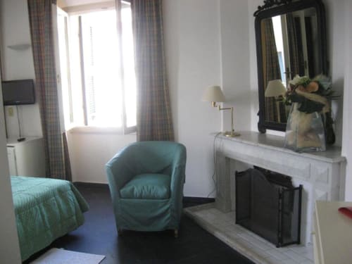 Hotelzimmer Beau Rivage in Alassio mit Kamin, türkisem Sessel und seitlichem Meerblick