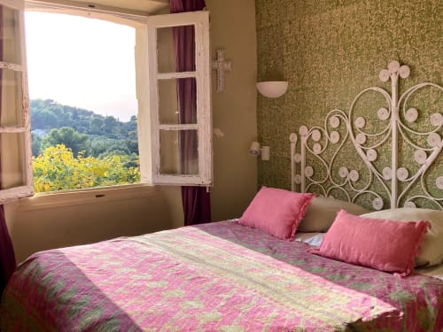 Charming bedroom at Saint Martin B&B in Ollioules with pink bedding, ornate headboard, and panoramic countryside views