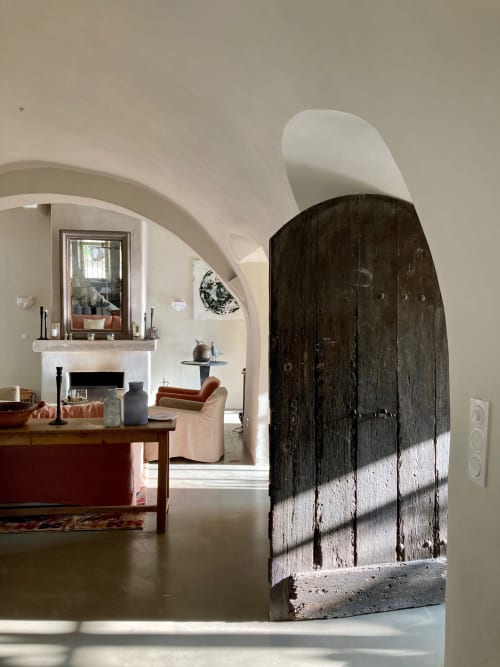 Porte rustique en bois ouvrant sur un élégant salon aux voûtes en arc à la maison d'hôtes Saint Martin à Ollioules