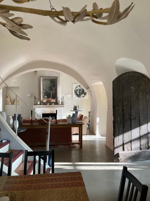 Saint Martin B&B in Ollioules features arched doorways, fireplace, and rustic wooden door in minimalist Mediterranean