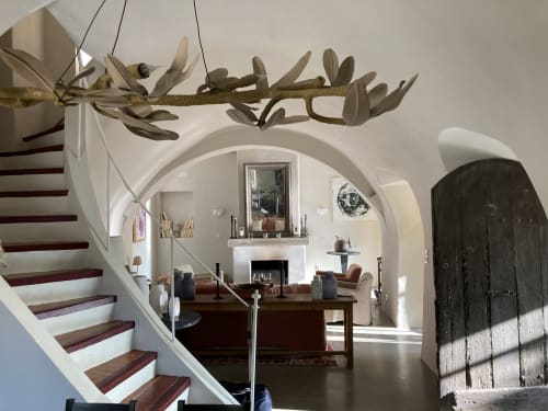 Le salon élégant de Saint Martin BnB à Ollioules avec plafonds voûtés, cheminée, escalier en bois et plantes suspendues