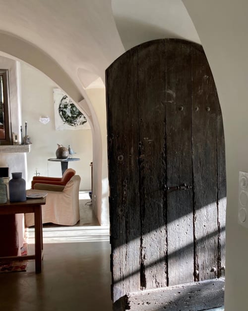 Rustic wooden door at Saint Martin B&B in Ollioules, France, with sunlit modern living room visible beyond