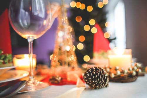 Festive holiday dining setup at Hotel Residence Europe & Spa with wine glass, pinecones, and seasonal décor in Clichy.