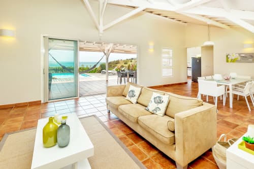 Le grand salon de la Villa Azura est totalement ouvert sur la piscine et son exceptionnelle vue mer. Grâce à sa double exposition, vous profiterez d'une ventilation naturelle très agréable.