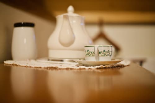 Service à thé élégant à La Bageatière avec théière blanche, tasses et linges délicats à Lépin-le-Lac