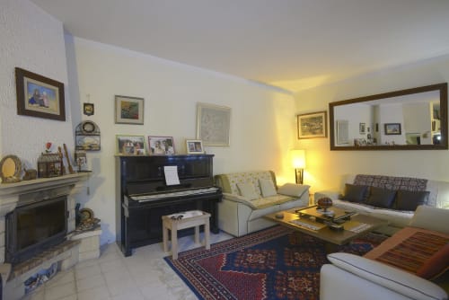 The living-room, the piano and the fireplace.