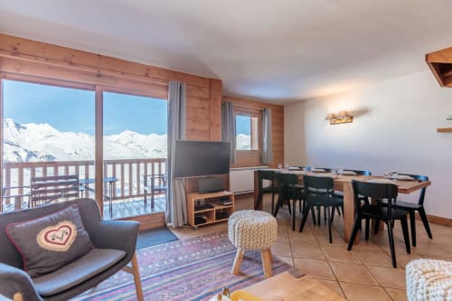 duplex apartment CosyArc Saint-Bernard in Arc 1800 featuring a modern living room with dining area, TV, and balcony with panoramic views of Mont Blanc