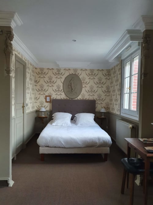 Chambre élégante de l'hôtel Les Cabines à Houlgate avec papier peint damassé, literie blanche et mobilier classique