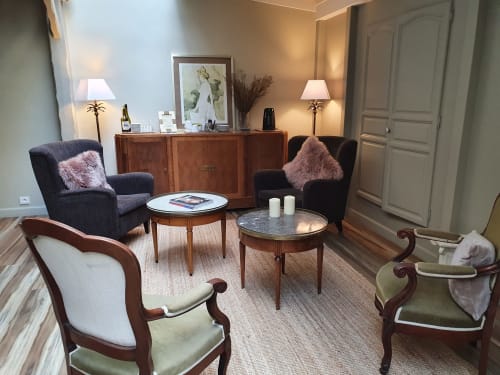 Élégant salon de l'hôtel Les Cabines à Houlgate avec fauteuils vintage, mobilier en bois et éclairage chaleureux