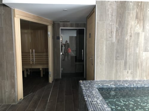 Modern spa bathroom at Le Champenois, Hermonville with sauna, hot tub, and wood finishes