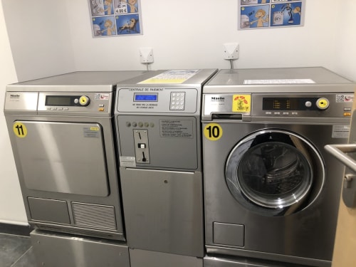 Laundry room with coin-operated dryers and washing machines at Le château d'Hermonville, Hermonville, France