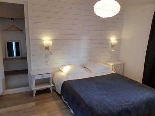 La chambre “parents” du Lodge avec un lit 160x200, liseuses et prise à hauteur