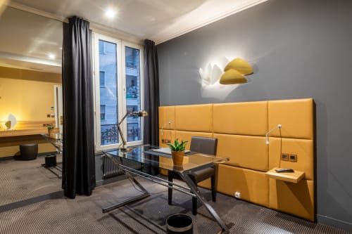 Modern hotel room at Hotel Residence Europe & Spa in Clichy with yellow headboard, desk, and contemporary décor
