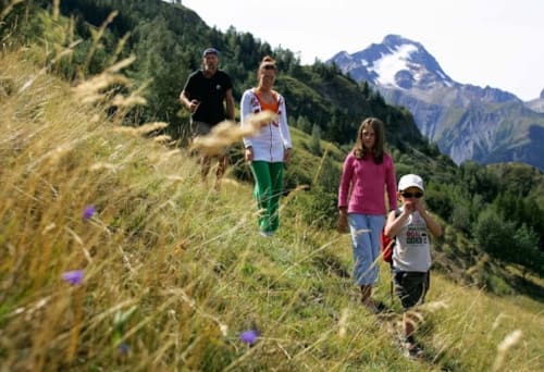 Famille en randonnée dans une prairie alpine avec sommet enneigé près d'Hermonville, France