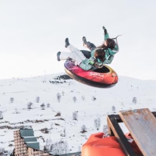 Guests sledding down snowy slope near Le château d'Hermonville, Hermonville France winter activity