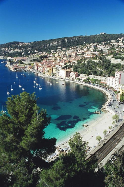 Vue aérienne de Villefranche-sur-Mer près de Nice avec ses eaux turquoise, voiliers et maisons colorées sur la colline