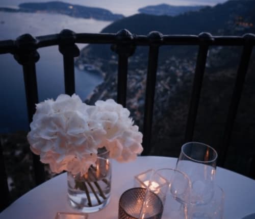 Œillets blancs dans un vase au coucher de soleil sur la terrasse de l'Hôtel De La Fontaine, vue sur la côte de Nice