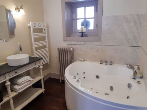 La spacieuse salle de bain de la Louisiane avec baignoire balnéo, double vasque et sèche-serviettes