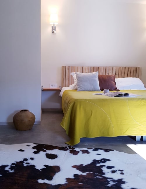 Slaapkamer Saint André in Moulin Renaudiots, Autun met gele beddengoed, gestoffeerde hoofdeinde en koeienhuid tapijt