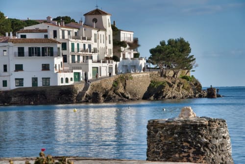 Gîte en bord de mer à Banyuls-sur-Mer, bâtiments méditerranéens blancs sur falaises rocheuses dominant la mer bleue