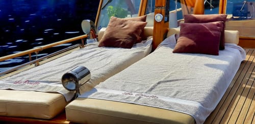 Lits de pont de luxe avec coussins bordeaux surplombant les eaux méditerranéennes de Banyuls-sur-Mer
