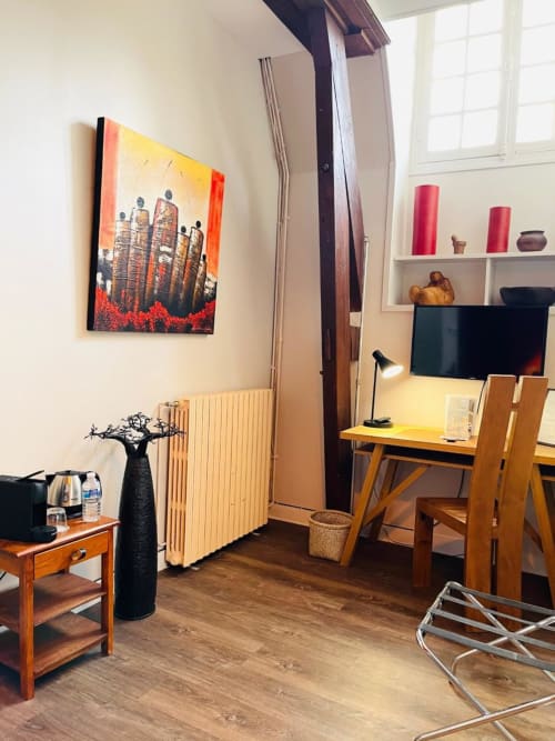 Coin bureau artistique avec tableau coloré, chambre maison d’hôtes à Evry, France, Essonne, ambiance chaleureuse, élégance, confort, sérénité.