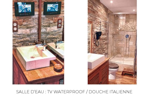 Salle de bain moderne du Banyuls BnB avec TV étanche, lavabo rose, murs en pierre et douche à l'italienne