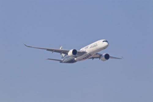 Airbus A350 in volo contro un cielo azzurro limpido, rappresentando i viaggi internazionali verso Verona, Italia