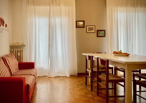 Common area with large table and relaxing sofa at B&B Ariel, rooms in the heart of Verona city center