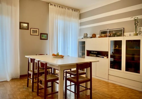 Dining and breakfast room at B&B Ariel, with decorative paintings in the background and terrace visible between the curtains, rooms in the heart of Verona city center