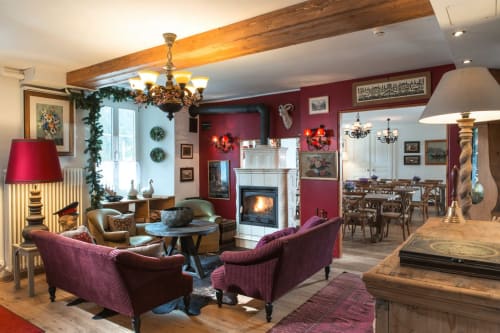 Salon chaleureux du Historic Hotel du Pillon avec cheminée allumée, fauteuils confortables et ambiance de chalet alpin traditionnel.
