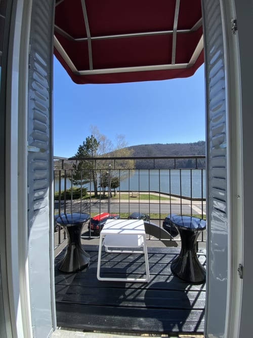 Le balcon privatif, son mobilier et la vue imprenable sur le lac Chambon.