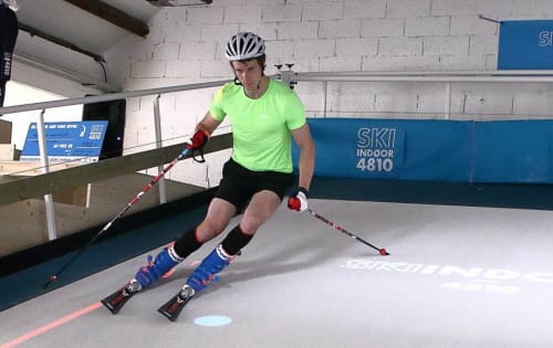 skieur en salle sur piste synthétique