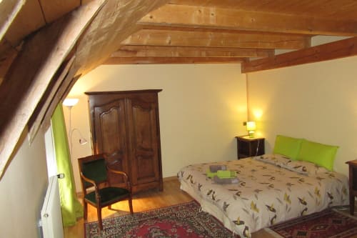 La chambre double au nom de la fleur Angélique aux Bastides du Mezenc avec charpente traditionnelle de ferme et plafond bois