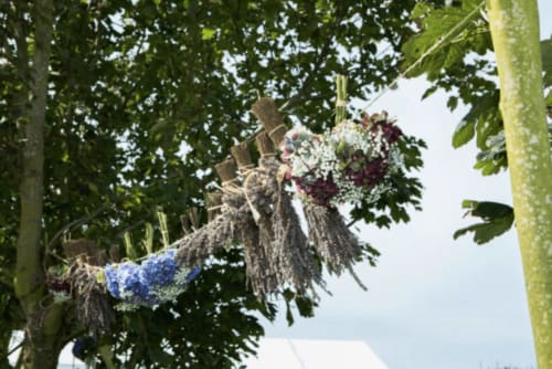 Hanging floral display with white and purple flowers adorning trees at Espace Ker Gana, Plourin