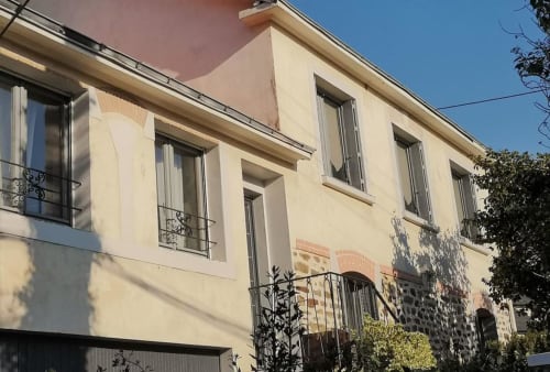 Façade de l'hôtel Orval Et Sens à Orvault avec murs crème, grandes fenêtres et rampes métalliques sous ciel bleu