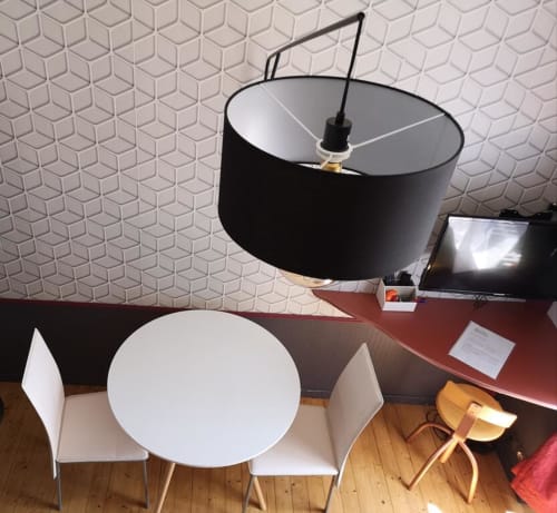 Salle à manger contemporaine de l'hôtel Orval Et Sens avec table ronde blanche, chaises assorties et luminaire suspendu noir
