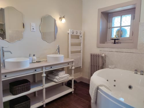 La spacieuse salle de bain de la Louisiane avec baignoire balnéo, double vasque et sèche-serviettes