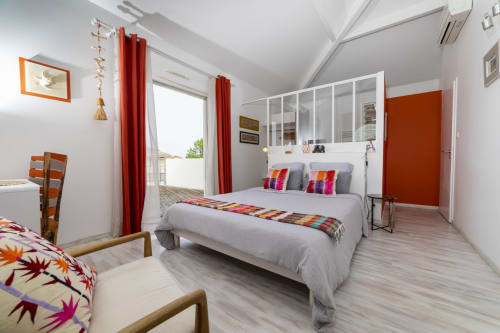 Chambre Byron Bay à Cote Et Dune à Biscarrosse Plage avec vue sur la piscine, lit moderne, coussins colorés et accès à la terrasse