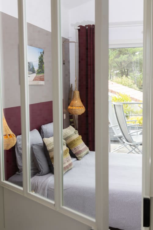 Suite Malibu à Cote Et Dune : tête de lit bordeaux, luminaires suspendus tissés et balcon avec vue sur l'océan à Biscarrosse Plage