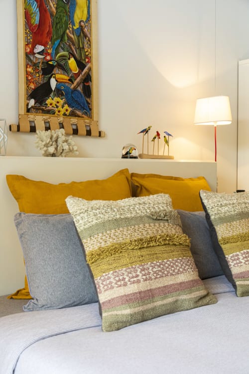 Chambre douillette à Cote Et Dune avec coussins dorés, housses rayées, tableaux d'oiseaux tropicaux et lampe de chevet à Biscarrosse